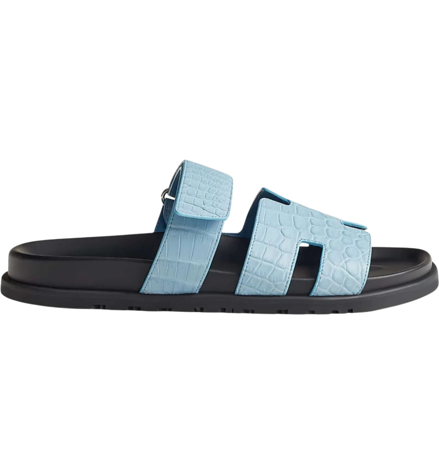 Light blue Hermès-style leather slide sandal with crocodile texture and black sole, shown in side profile.